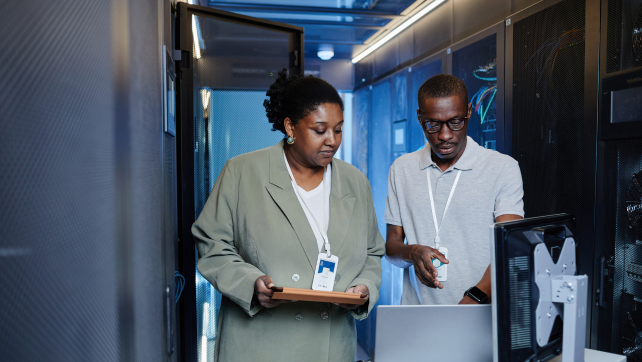 Two AI professionals standing and looking at a computer screen together